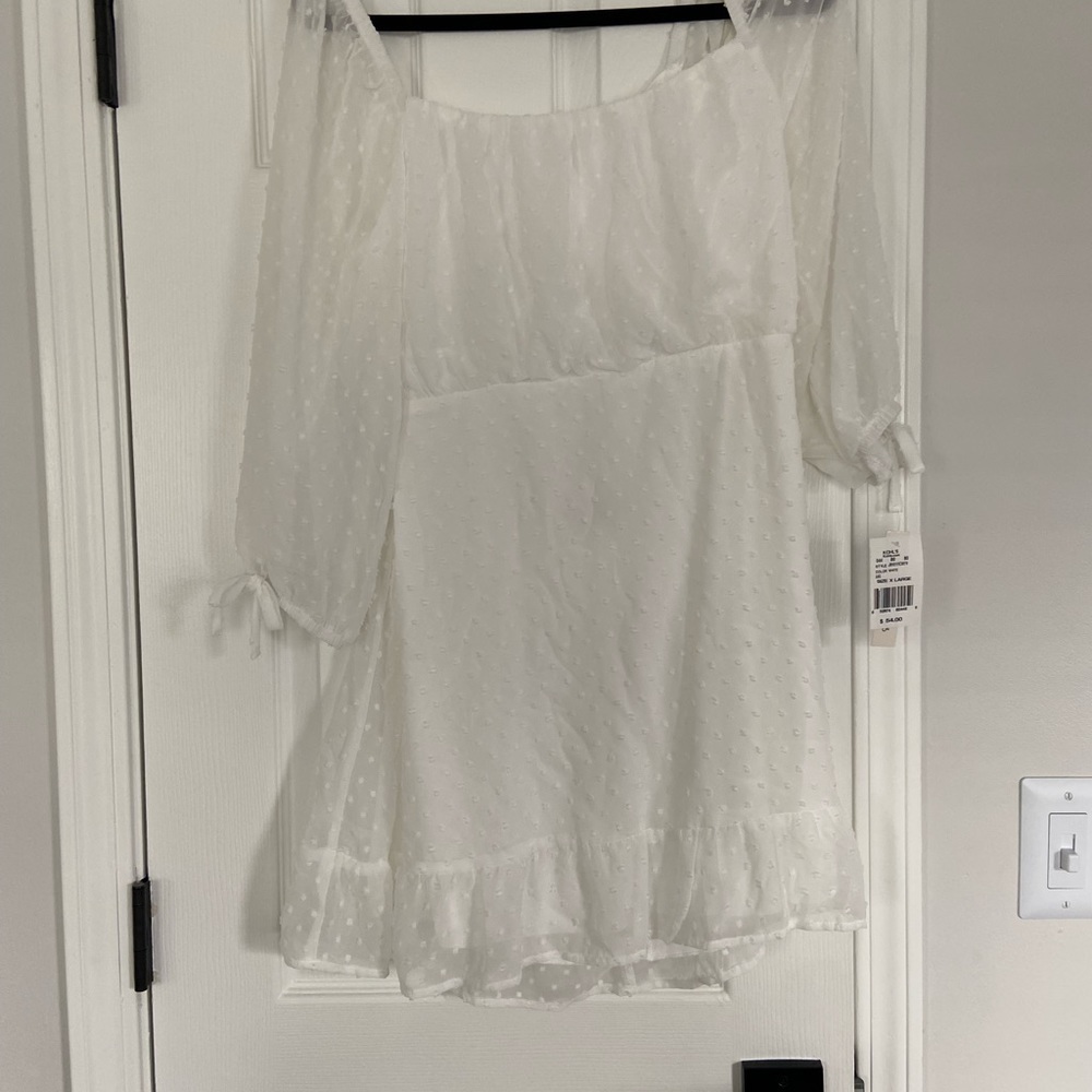 White short dress with long sleeves back is cut out.